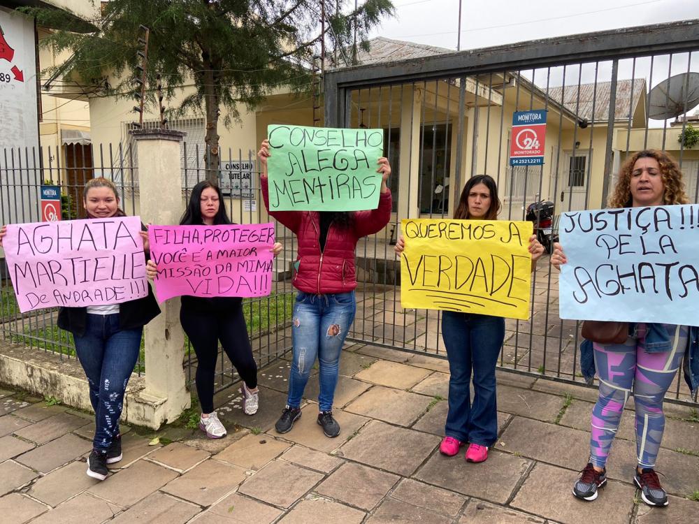Marília de Andrade (com o cartaz amarelo) quer sua bebê de 3 meses de volta e diz que não irá entregar a filha de 3 anos. 