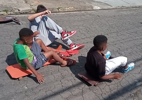 Crianças brincam com um carrinho de rolimã (Crédito: Divulgação)