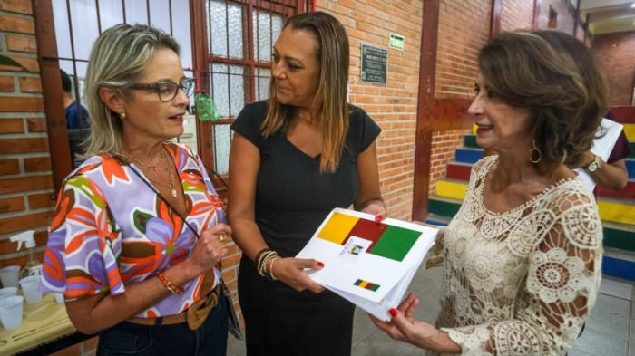 As secretárias Izabel e Raquel entregam a publicação para a diretora Rosane Pires -Foto: Gustavo Mansur/Secom