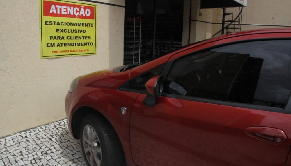 Placas querendo proibir estacionamento em vagas de recuo são comuns em vários pontos da cidade.