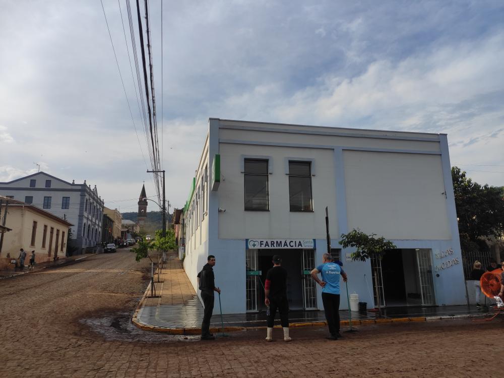 Moradores limpando dois comércios do centro de Santa Tereza afetados pela enchente. Crédito: Renata Oliveira/NB
