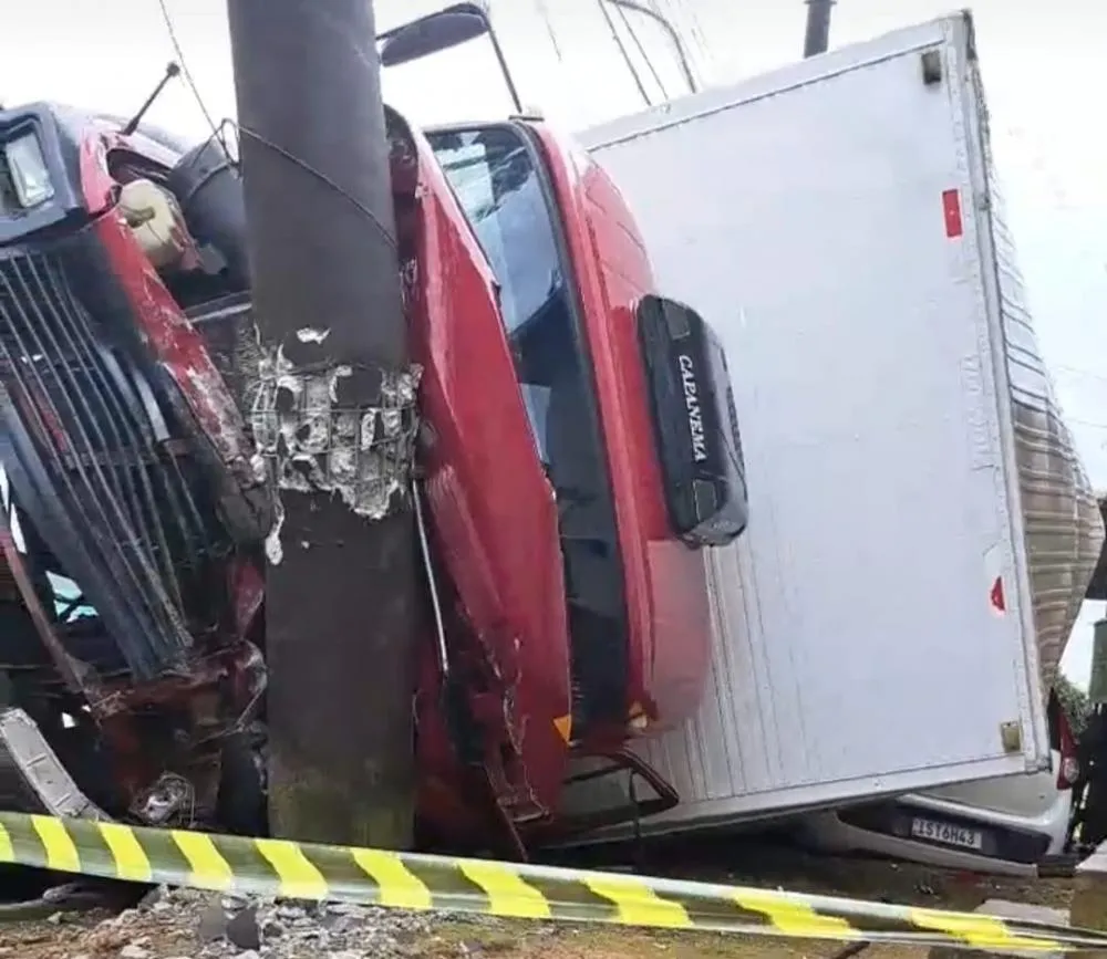 Caminhão tomba, cai sobre automóvel e colide contra um poste em Caxias do Sul